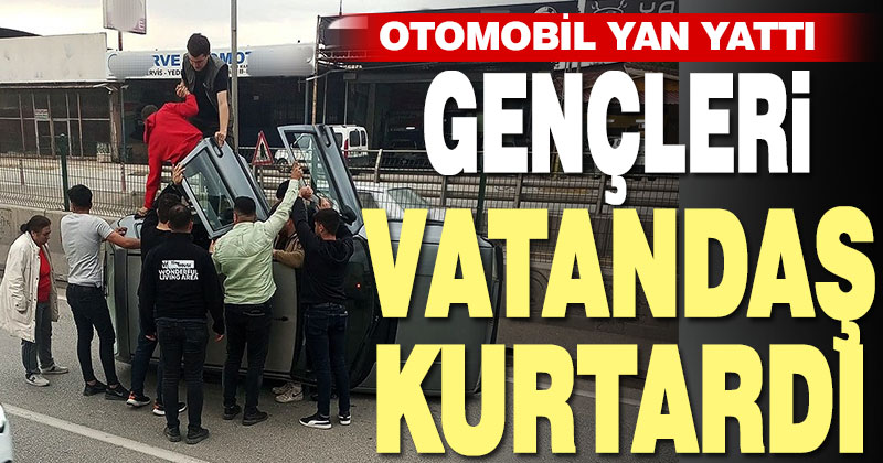 Yan yatan otomobildeki gençleri vatandaşlar kurtardı